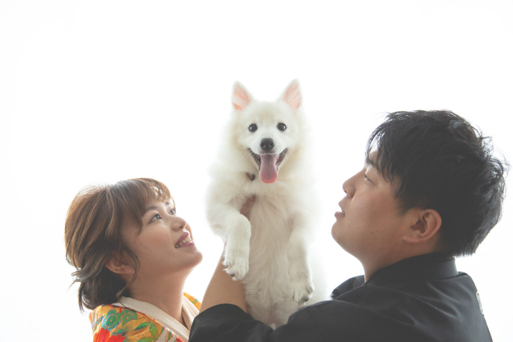 和装でわんちゃんを抱き上げる新郎新婦様