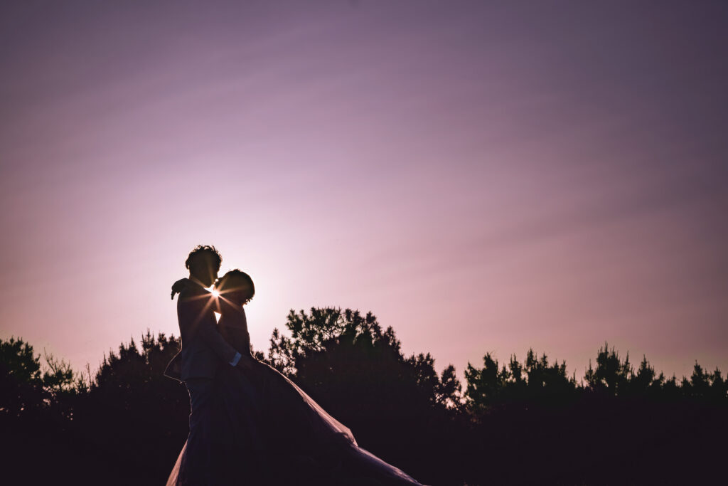 徳島の小松海岸で夕陽の中ウェディングフォトを撮影する新郎新婦