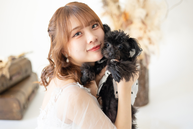 洋装の新婦様が黒いわんちゃんを抱っこ